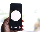 A hand holding a smartphone with a voice assistant interface on the screen