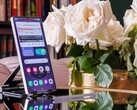 A Samsung Galaxy S25 Ultra standing upright on a table, an open website visible on the display