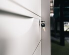 A key sitting in the lock of a closed wooden drawer