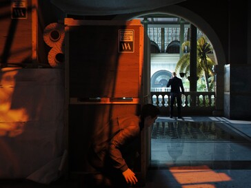 James Bond hides behind boxes.