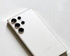 White Samsung Galaxy smartphone with four rear cameras on a light surface