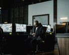 A security analyst in a control room in front of several monitors
