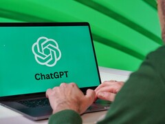 Person typing on a laptop showing the ChatGPT logo on screen