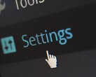Close-up of a screen showing a Settings menu item and a mouse pointer