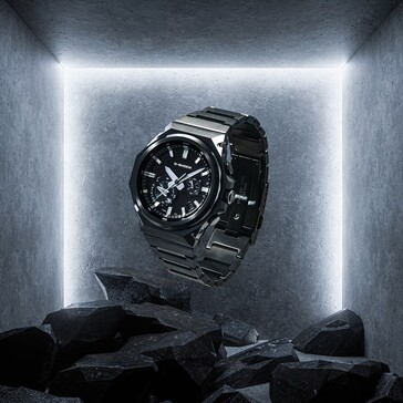 G-Shock GST-B1000BD-1A suspended above dark rocks in a concrete display space, highlighting its black stainless steel construction.