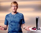 Mark Cerny during a PlayStation event, seated beside a PS5 console and DualSense controllers. (Image Source: Sony Interactive Entertainment)