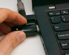 A person inserts a USB security key into a laptop