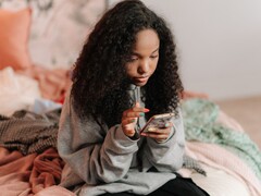 Teenager using a smartphone on a bed, symbolic image for ChatGPT for Teens and parental controls