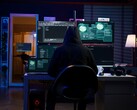 Hooded figure at a multi-screen setup running a cyberattack.