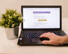 Laptop on a table showing a phishing email with a confirmation button
