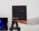 3D-printed ITG Cube gaming PC shown in hand, featuring a compact Steam Machine-style enclosure with front I/O ports and minimalist design.