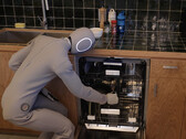 The humanoid home robot 1X Neo is loading a dishwasher (Image source: WSJ on YouTube/screenshot).