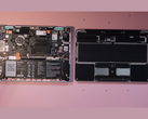 A torn-down Framework 12.2 laptop next to a MacBook Neo