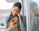 A woman looks at her smartphone with a serious expression